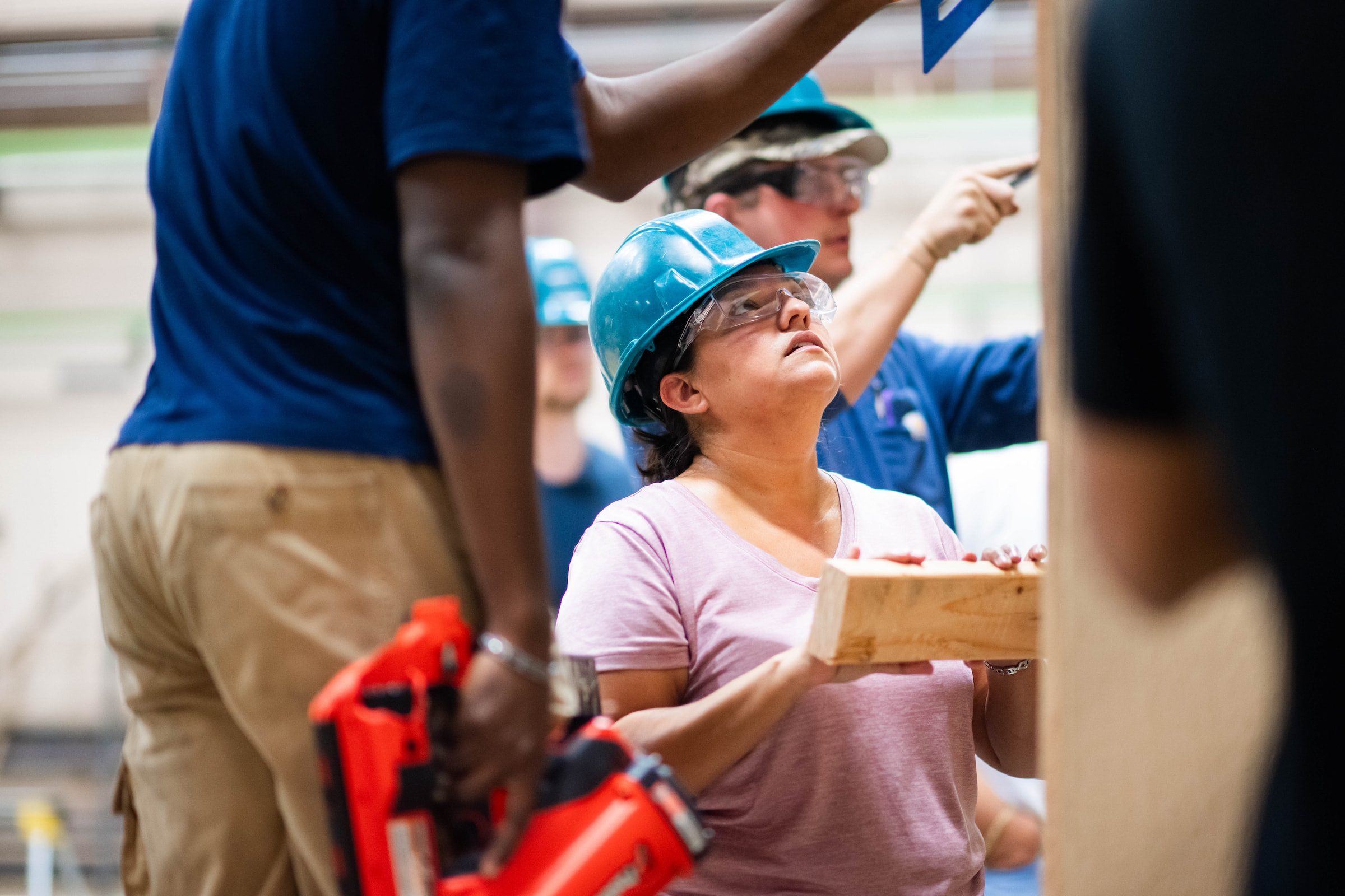 A female student in a hard hat working on the tiny home