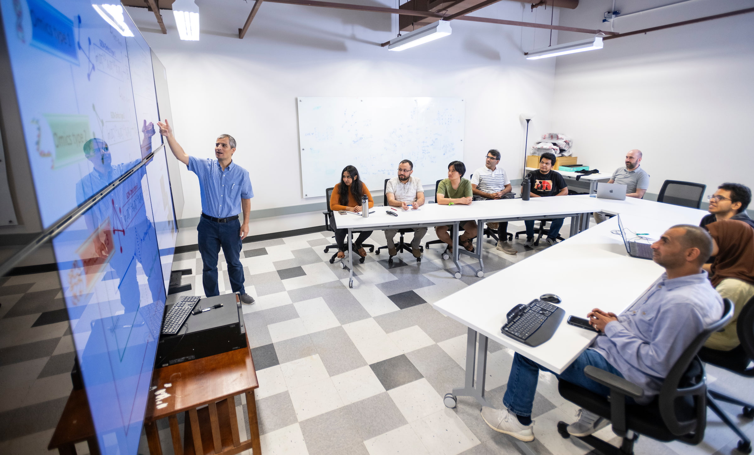 Bozdag explaining formulae on a board