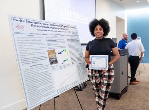 MeSha McClanahan Shows Off Her Award and Research Poster About Fire Ants and Fungi 