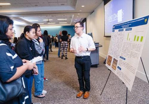 Photo: UNT Dallas Biology Major Connor Hester Explaining His Polystyrene Degradation Research